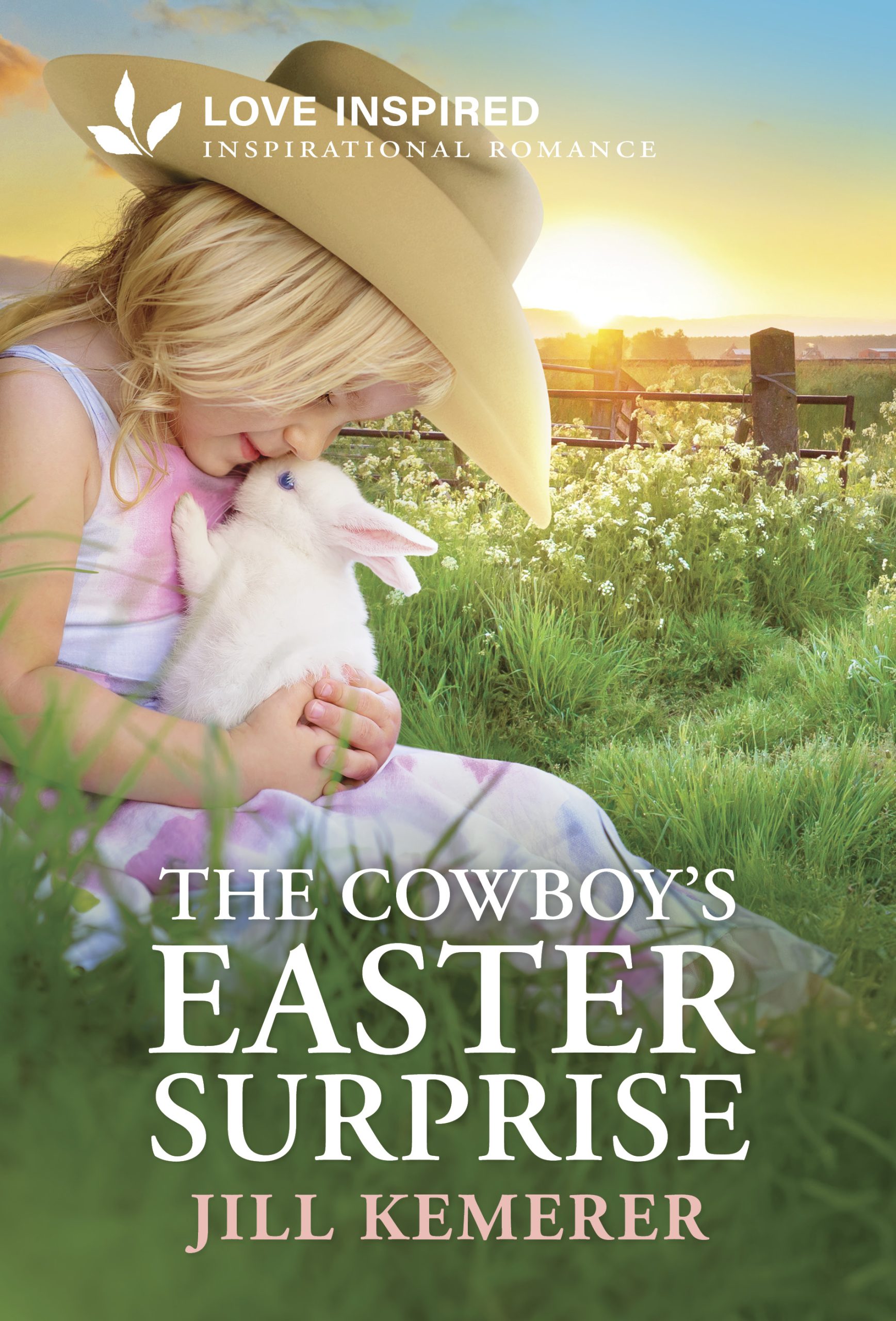 Cover of The Cowboy's Easter Surprise by Jill Kemerer. Grass and pasture with 4-year old girl wearing a sundress and cowboy hat holding a white baby bunny