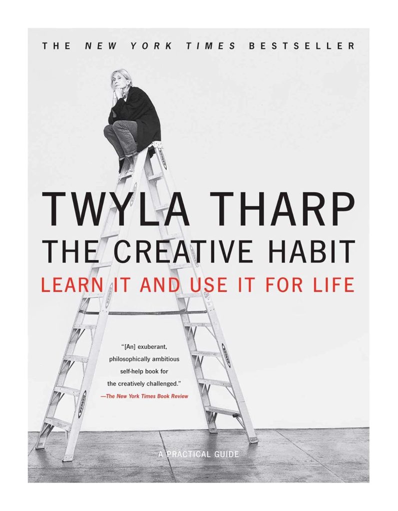 Book Cover. The Creative Habit by Twyla Tharp. White background with Twyla sitting on the top of a ladder