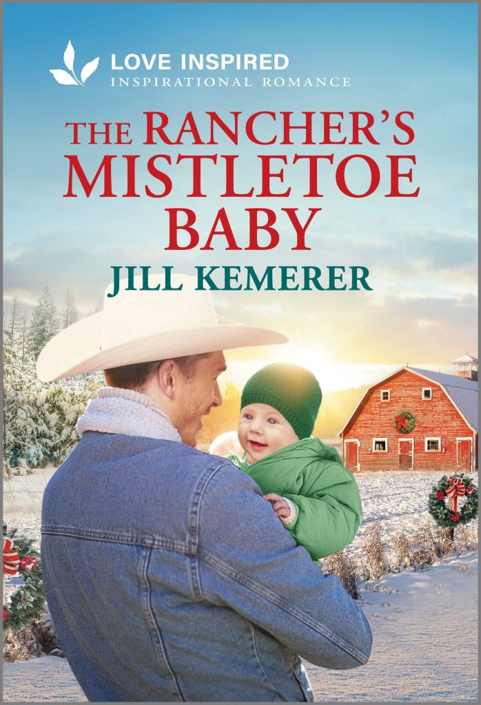 Snowy Wyoming background with red barn and wreaths. Cowboy smiling as he holds a baby in a green snowsuit and stocking cap. The Rancher's Mistletoe Baby by Jill Kemerer